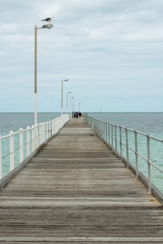 Looking out along a wharf with people at the end of the wharf - Australian Stock Image