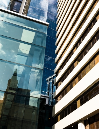 Looking up at high rise city buildings and reflections filling the frame - Australian Stock Image