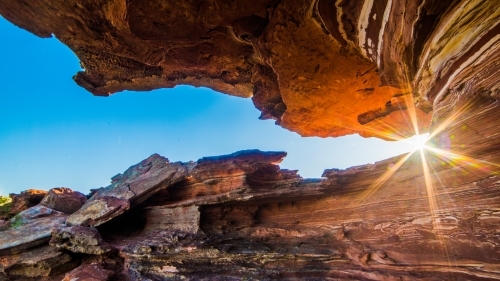 Looking up the rocky terrain with sun shining through - Australian Stock Image