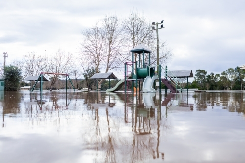 low level view of park play equipment under water during flood - Australian Stock Image