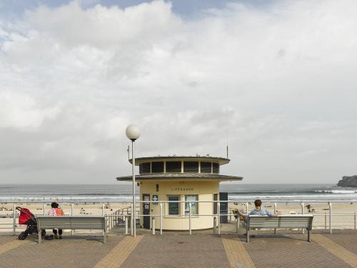 Man and woman with pram on Bondi Beach promenade - Australian Stock Image