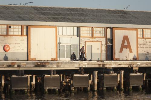 man fishing near A Shed at fremantle - Australian Stock Image