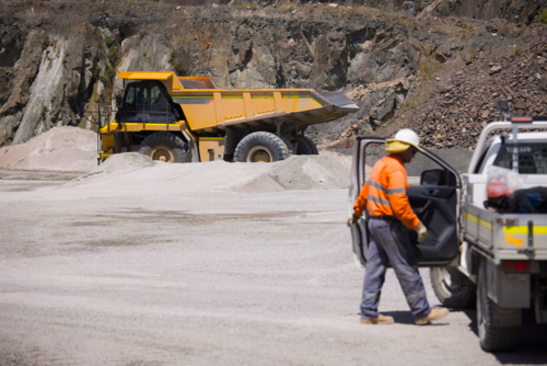 Man in high visibility clothing opening the door of his ute in open cut mine - Australian Stock Image