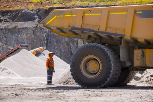 Man in workwear checking the back end of the hauler truck. - Australian Stock Image