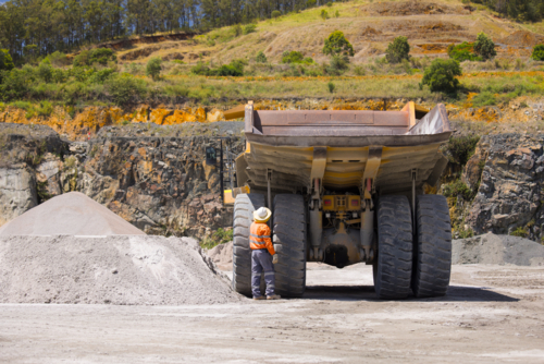 Man in workwear checking the rear wheels of the hauler truck. - Australian Stock Image