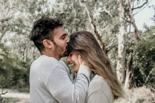 Man kisses young woman on the head. - Australian Stock Image