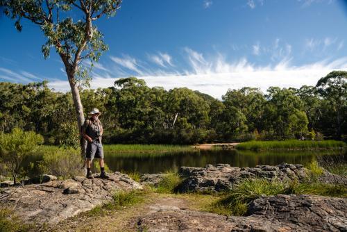 Man looking out at scenic waterway - Australian Stock Image