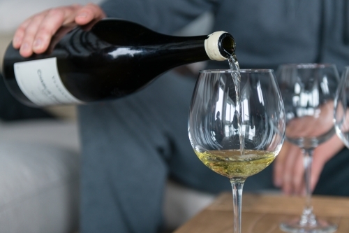 man pouring white wine - Australian Stock Image
