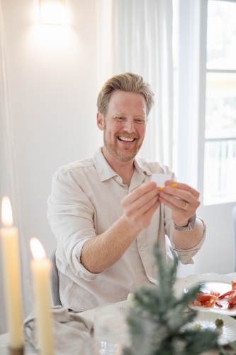 Man reading joke from Christmas cracker - Australian Stock Image