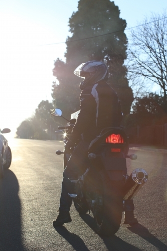 Man riding motorbike on a suburban street - Australian Stock Image