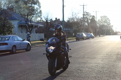 Man riding motorbike on a suburban street