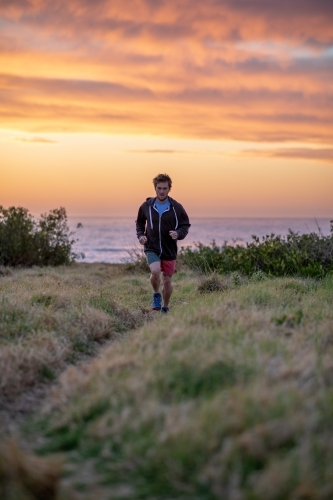 Man Running in Nature Under Pastel Sky - Australian Stock Image