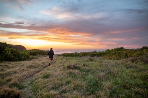 Man Running Towards Beach at Sunrise - Australian Stock Image