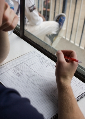 man scoring at a cricket match - Australian Stock Image