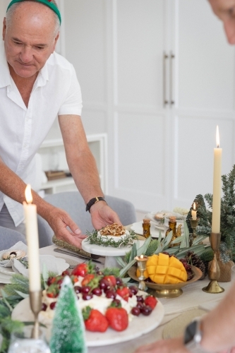 Man setting up table for Christmas - Australian Stock Image