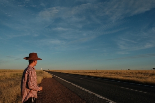 Man standing on the side of the road near Winton Queensland - Australian Stock Image