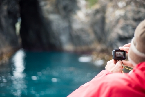 Man using GoPro video camera on boat - Australian Stock Image