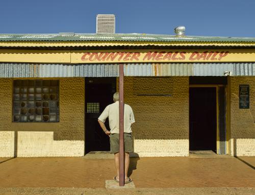 Man waiting standing outside Tennant Creek Hotel - Australian Stock Image