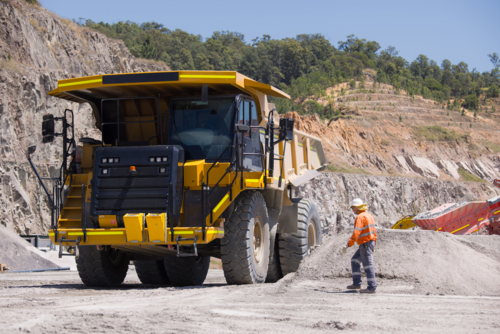 Man walking towards the dump truck with massive wheels. - Australian Stock Image