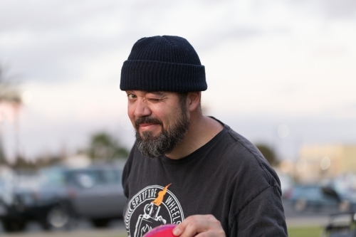 Man wearing a beanie looking at camera and winking - Australian Stock Image