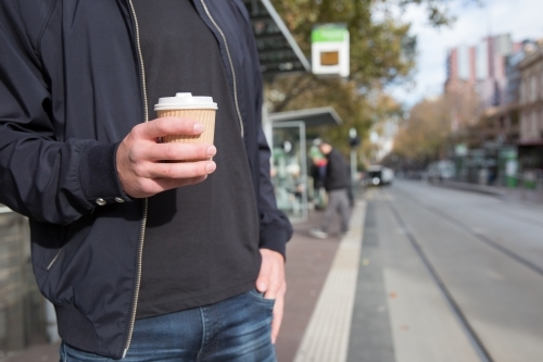 Man with Coffee Waiting for Melbourne Tram - Australian Stock Image