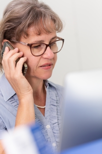 Mature business woman holding phone to ear - Australian Stock Image