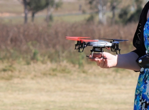 Mini UAV held by a woman in her hand before take off - Australian Stock Image