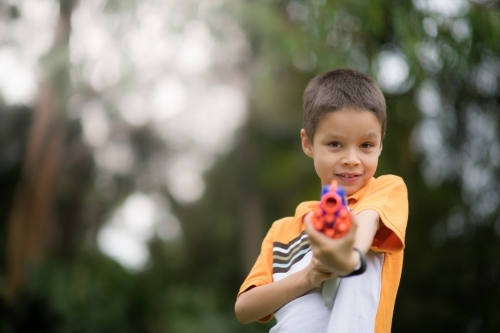 Mixed race boys playing outside with Nerf dart guns - Australian Stock Image