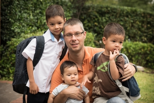 Mixed race boys say good-bye to their dad on their first day of school - Australian Stock Image