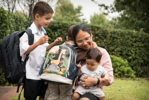 Mixed race boys say good-bye to their mum on their first day of school - Australian Stock Image