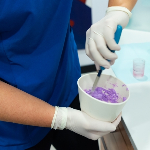 Mixing dental alginate to take teeth impressions - Australian Stock Image