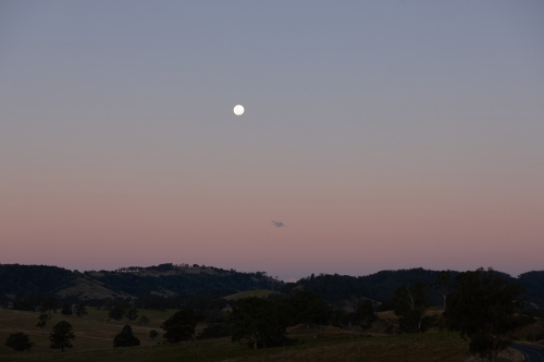 Moon rising over landscape