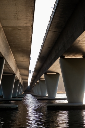 Morning sun shining underside of concrete bridge on Swan River - Australian Stock Image