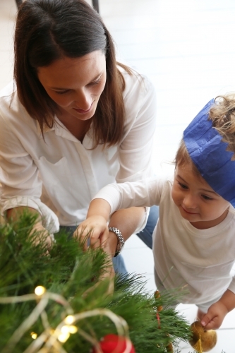 Mother and daughter decorating Christmas tree - Australian Stock Image