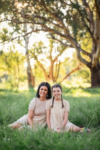 Mother and daughter sitting together in natural Australian bush setting - Australian Stock Image