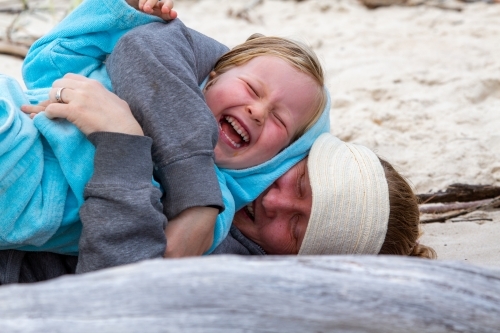 Mother and four year old daughter cuddling and laughing. - Australian Stock Image