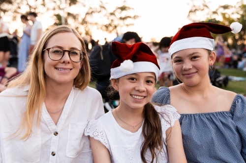 mother and her teenage daughters at a Christmas community event - Australian Stock Image