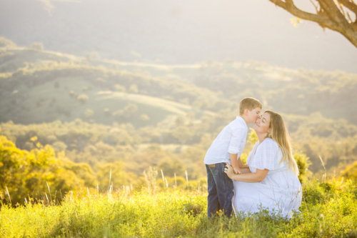 Mother and son embracing in intimate moment on hilltop - Australian Stock Image