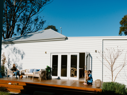 Mother and son spending time outside in the wooden deck. - Australian Stock Image