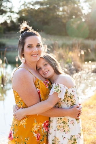 Mother and young daughter hug - Australian Stock Image