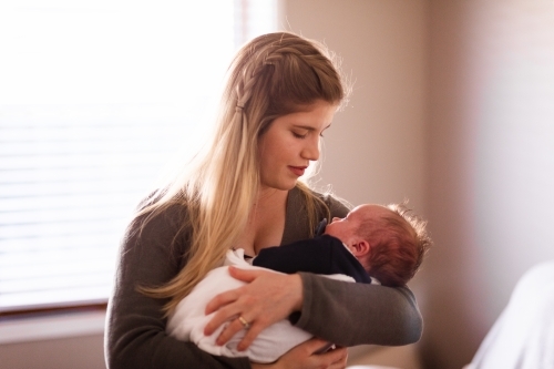 Mother cuddling newborn baby - Australian Stock Image