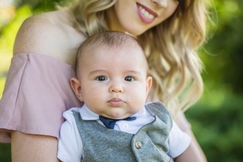 Mother looking down at child smiling - Australian Stock Image