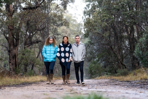 Mother, son and daughter walking on dirt track - Australian Stock Image