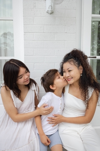 Mother, son and daughter wearing white sitting together