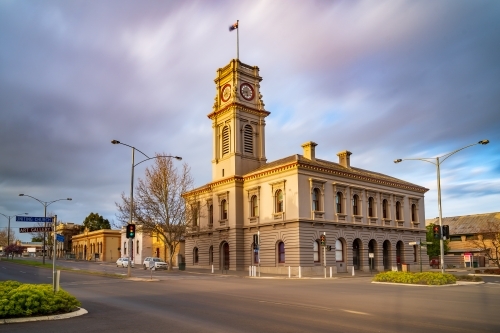 Moving clouds over a rural town intersection with an historic post office - Australian Stock Image