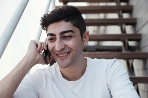 multicultural young adult man on the phone - Australian Stock Image