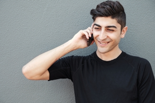 multicultural young adult man on the phone - Australian Stock Image