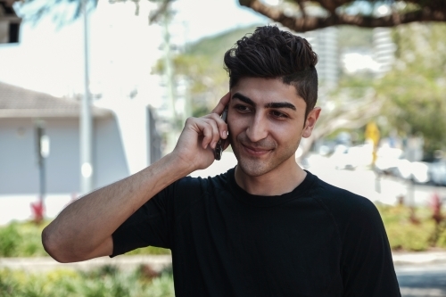 multicultural young adult man on the phone - Australian Stock Image