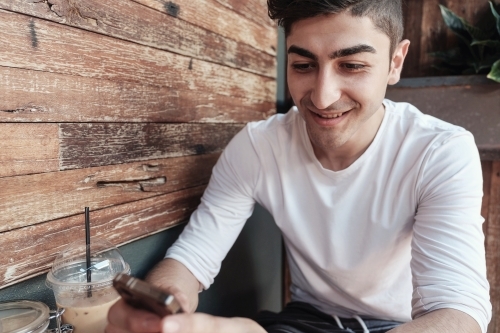 multicultural young adult man using smartphone - Australian Stock Image