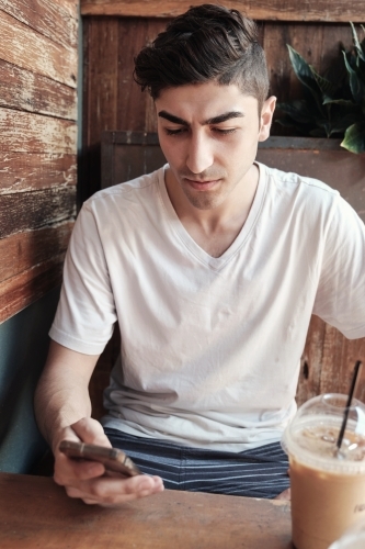 multicultural young adult man using smartphone - Australian Stock Image